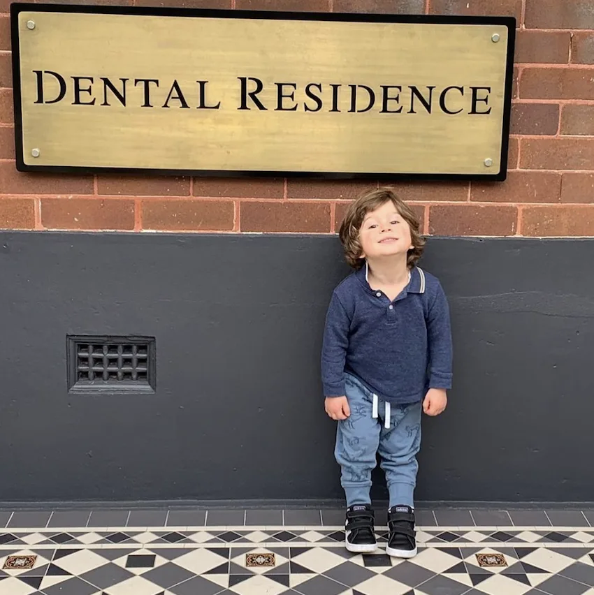 Young boy in front of the dental residence - marrickville dentist sign.